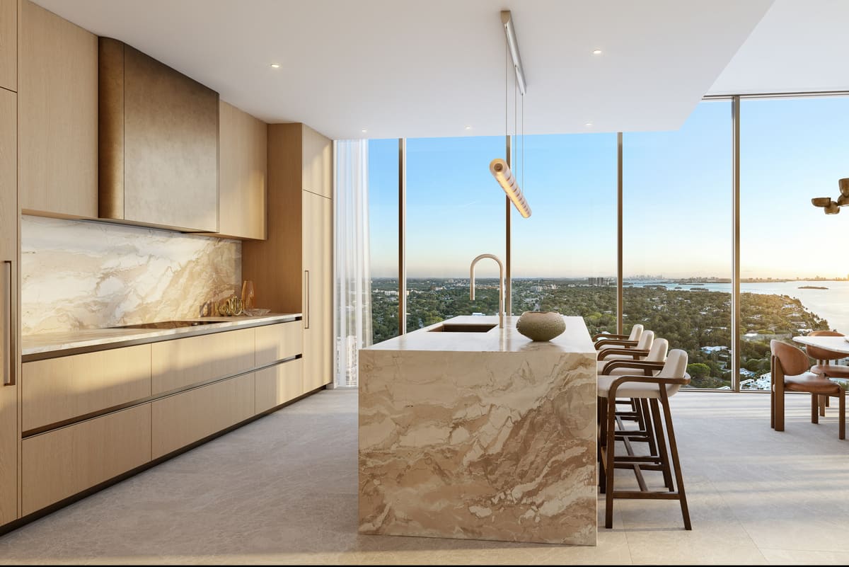 A residence kitchen with Rockwell Group cabinetry, natural stone waterfall island and Gaggenau appliances
